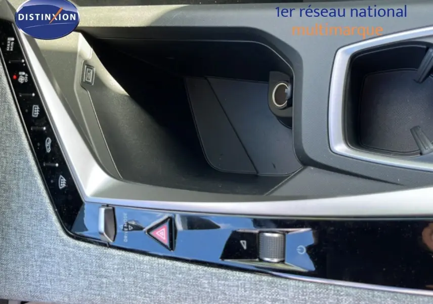 Gros plan sur la console centrale intérieure du Peugeot 5008 gris Artense, montrant les commandes et un espace de rangement.