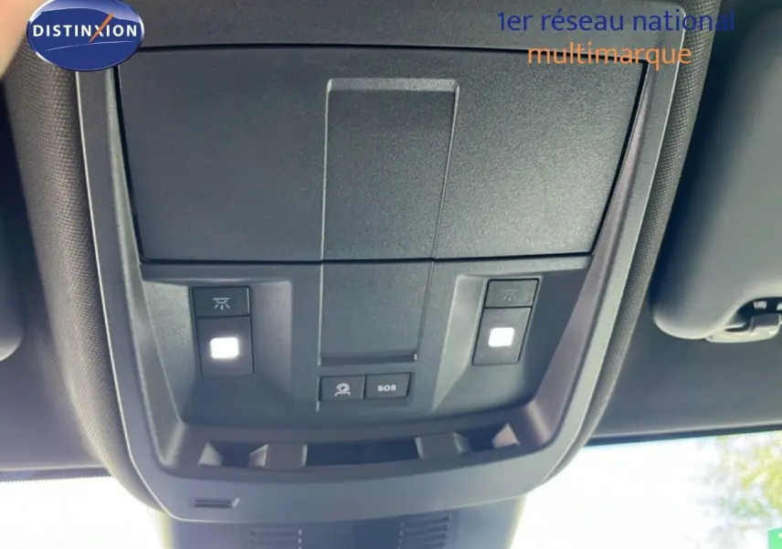 Vue intérieure en gros plan du plafonnier avec commandes d’éclairage et bouton SOS du Peugeot 5008 gris Artense 2025.