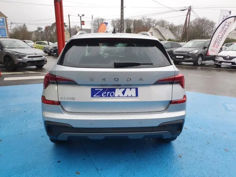 Vue arrière d'un Skoda Kamiq gris diamant métallisé avec feux arrière LED et logo SKODA visible sur un parking.