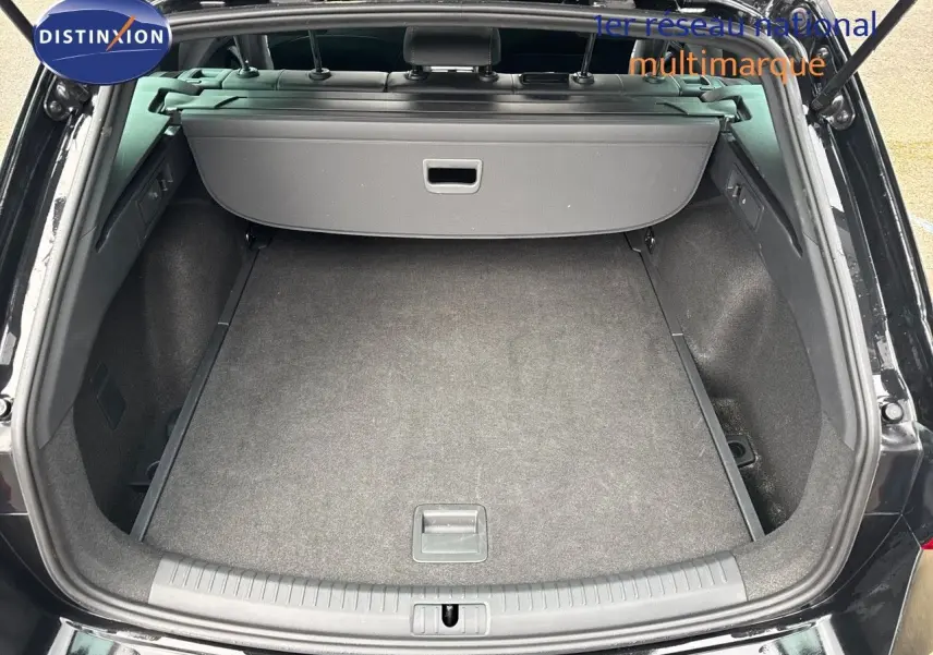 Coffre ouvert vu de l'arrière d'une CUPRA LEON ST 1.5 ETSI noire, montrant un espace de chargement propre et spacieux.