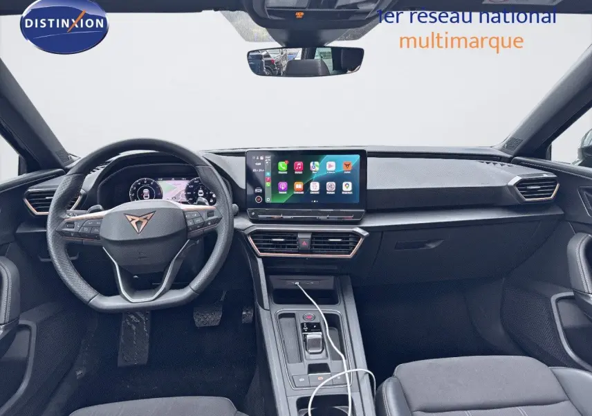 Intérieur noir du CUPRA LEON ST 2024 vu de face, avec tableau de bord numérique et écran tactile central lumineux.