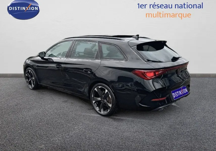 Vue 3/4 arrière droite d'une CUPRA LEON ST noire Midnight Metal avec jantes bi-ton et feux LED distinctifs.