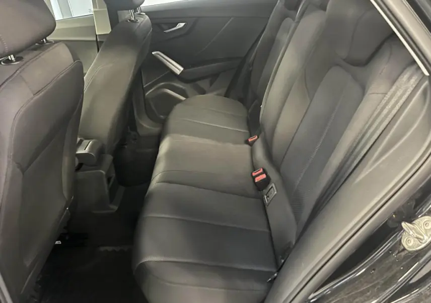 Vue intérieure côté droit des sièges arrière noirs en tissu de l'Audi Q2 Business line 2022 avec accoudoir central avant visible.
