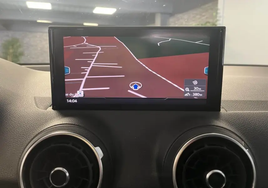 Écran central du système de navigation de l'Audi Q2 2022 avec ventilation circulaire noire et argentée visible en bas.