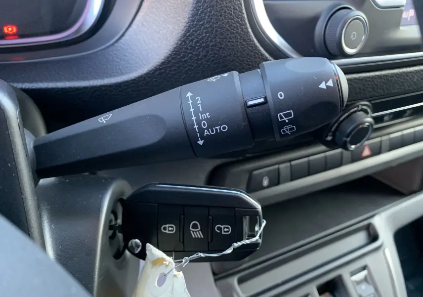 Gros plan sur la commande d'essuie-glace et la clé insérée dans le contacteur d'un Fiat Scudo Combi blanc électrique 2022.