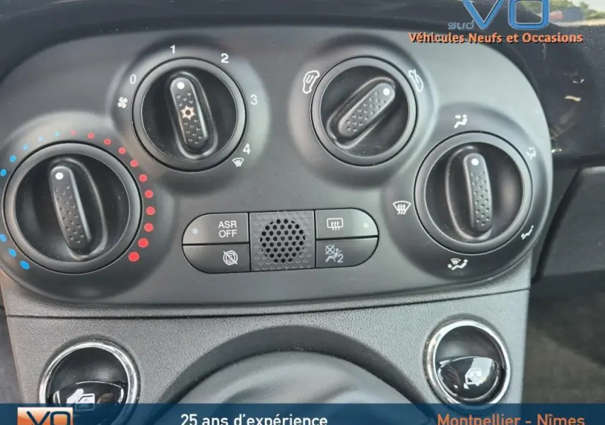 Tableau de bord noir de la Fiat 500C 2024 avec commandes manuelles de climatisation et ventilation visibles.