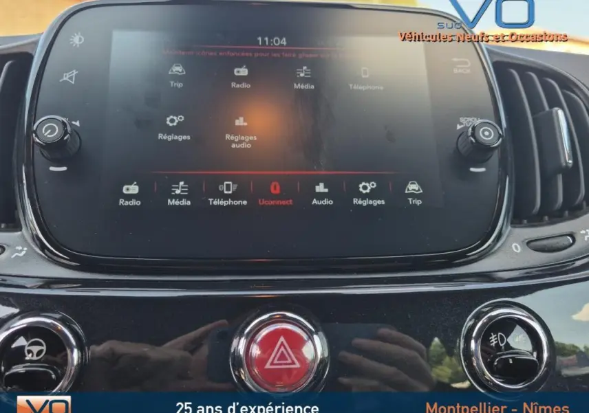 Écran tactile central de la console d'une FIAT 500C noire 2024, affichant les options multimédia et réglages.