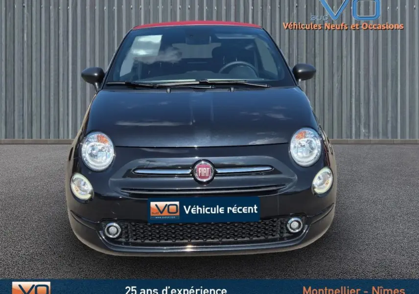 Vue avant d'une FIAT 500C noire avec toit rouge, phare rond et logo FIAT centré sur la calandre.