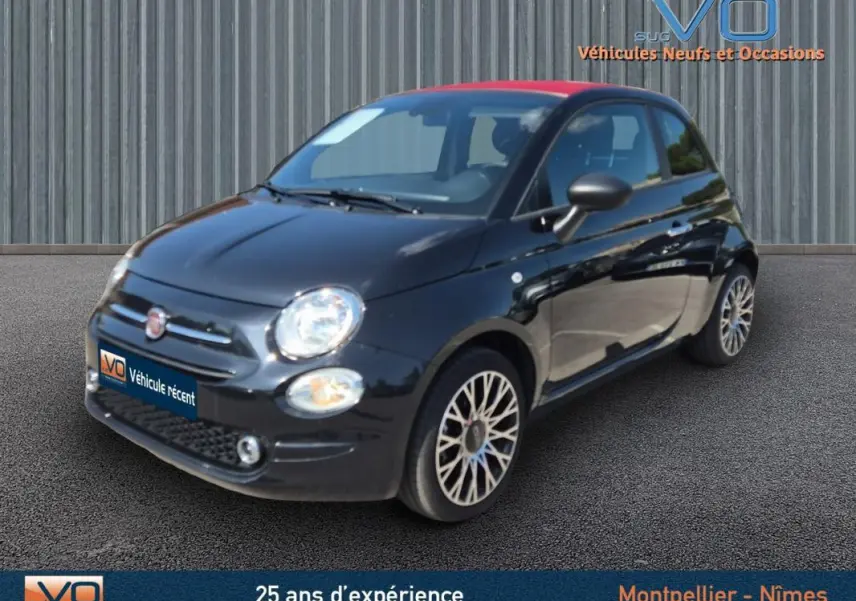 Fiat 500C noire vue 3/4 avant droit avec toit rouge et jantes alliage, modèle 2024 hybride essence.