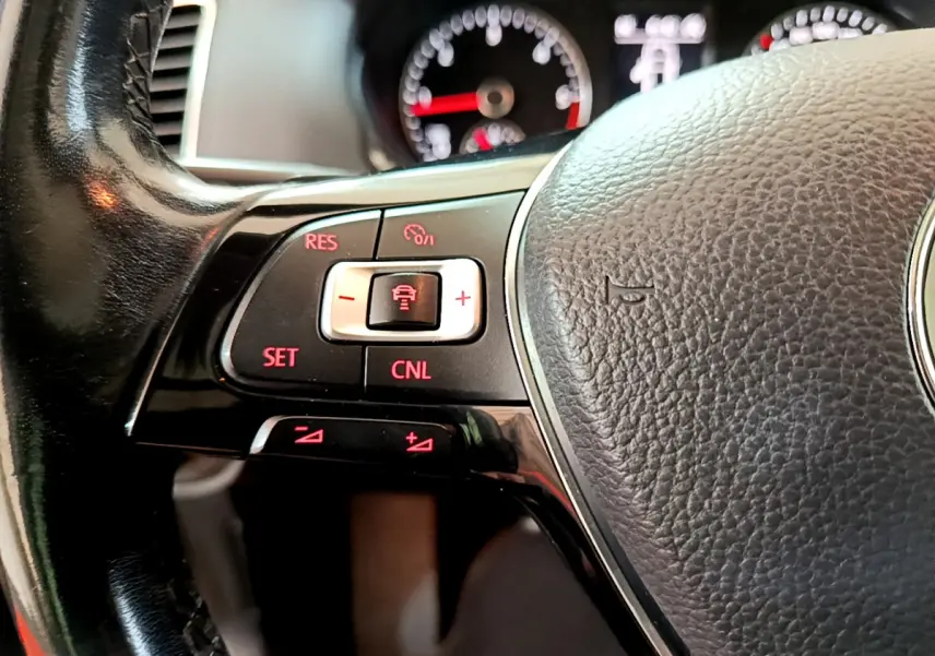 Gros plan sur le volant cuir noir du Volkswagen Sharan 2017, avec commandes de régulateur adaptatif éclairées en rouge.