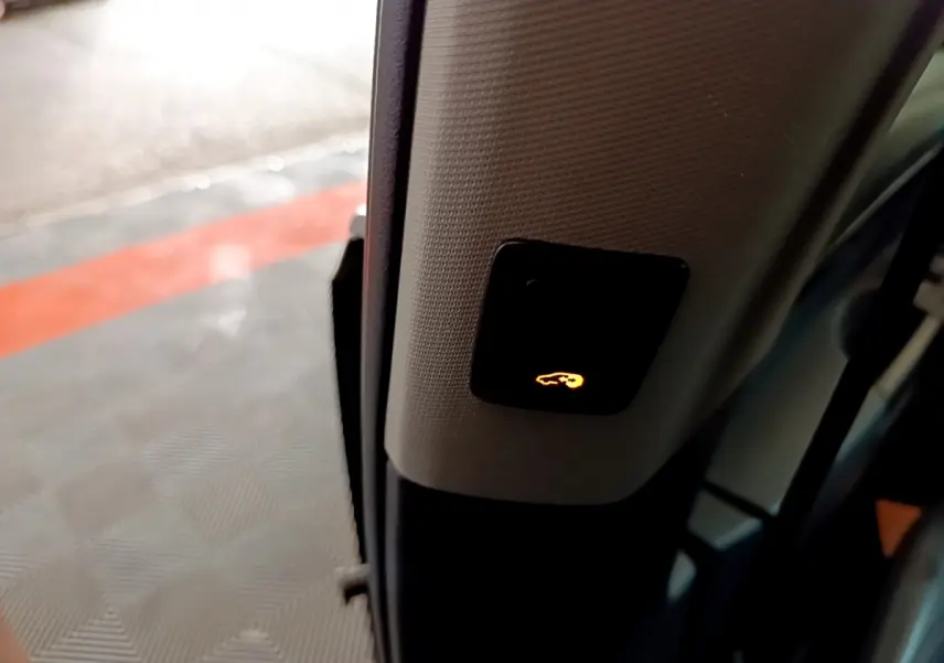 Bouton lumineux d'ouverture électrique du hayon visible sur le montant intérieur d'une Volkswagen Sharan marron 2017.