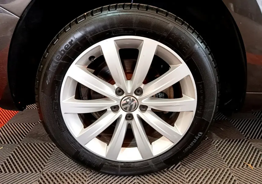 Gros plan sur la roue avant droite du Volkswagen Sharan marron, mettant en valeur la jante alliage à dix branches et le pneu Kleber.