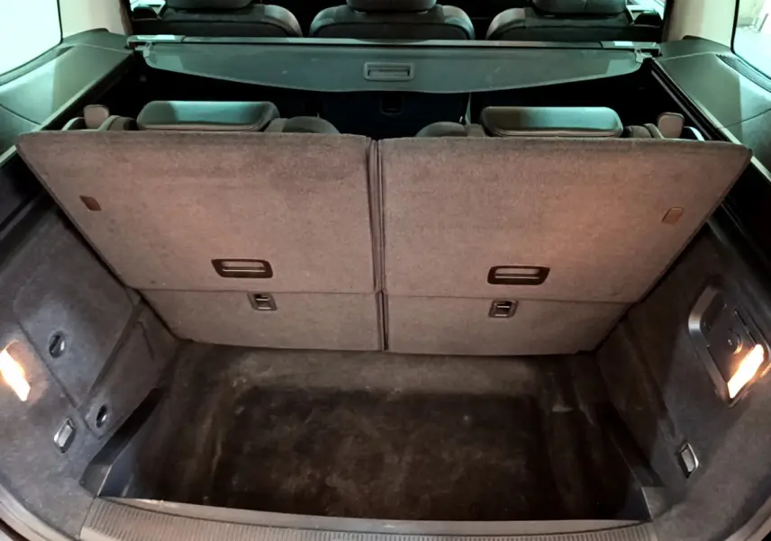 Coffre ouvert du Volkswagen Sharan marron 2017, montrant la 3ème rangée de sièges rabattue et l'espace de chargement.