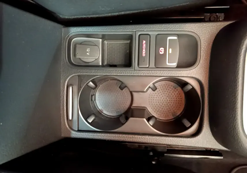 Gros plan sur la console centrale noire du Volkswagen Sharan 2017, avec porte-gobelets et commandes électroniques.