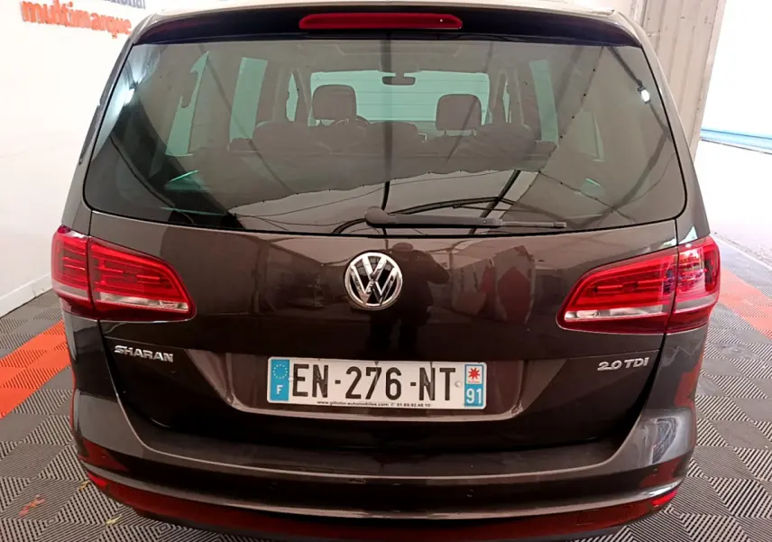 Vue arrière d'un Volkswagen Sharan marron 2.0 TDI avec feux rouges et logo VW bien visibles.