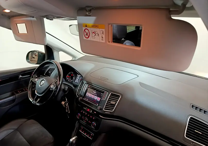 Intérieur avant du Volkswagen Sharan marron 2017, tableau de bord et volant cuir avec écran tactile central visible.