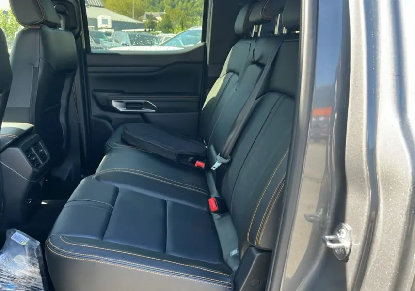 Vue intérieure côté droit des sièges arrière en cuir noir avec surpiqûres jaunes du Ford Ranger gris carbone 2025 Wildtrak Plus.