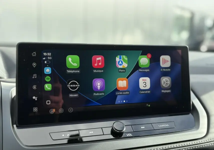 Écran tactile central du tableau de bord du Nissan Qashqai blanc nacré, affichant Apple CarPlay.