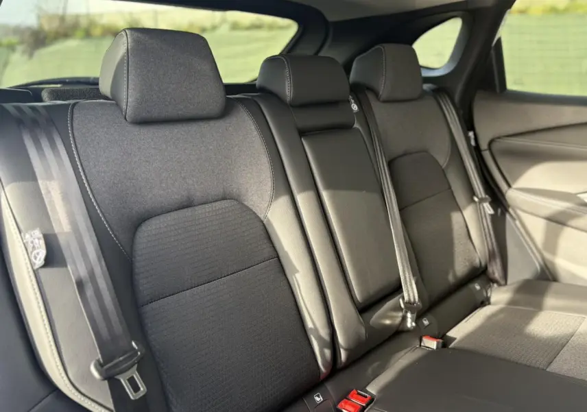 Vue intérieure des sièges arrière noirs du Nissan Qashqai III e-Power 2025, avec ceintures de sécurité visibles.