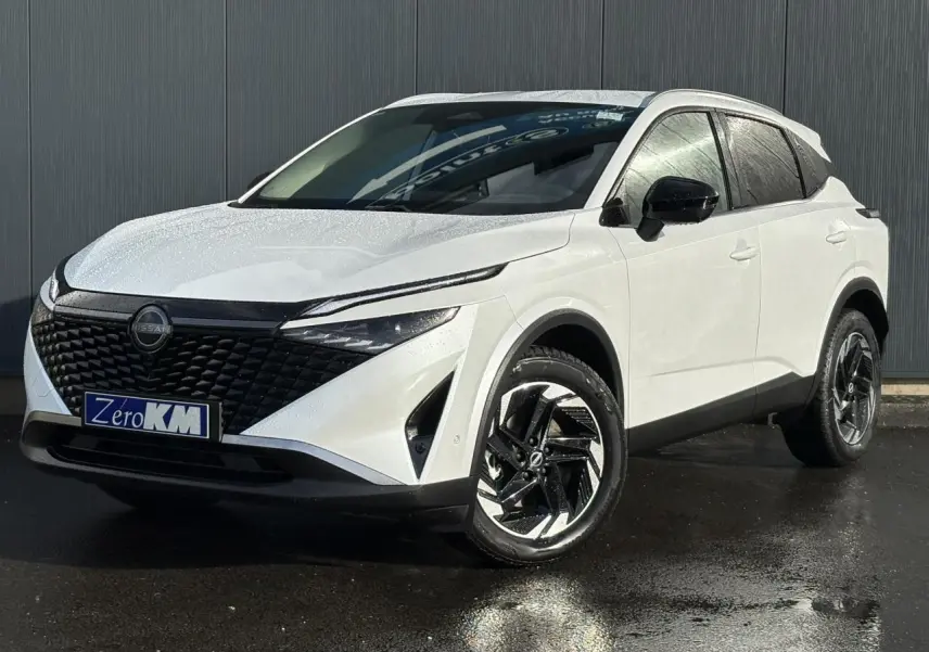 Vue 3/4 avant droit du Nissan Qashqai blanc nacré avec calandre noire et jantes alliage bicolores.