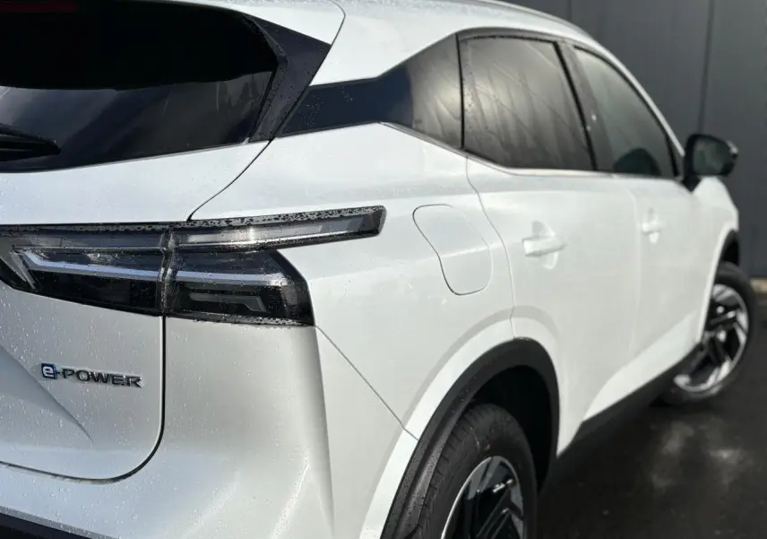 Vue 3/4 arrière droite du Nissan Qashqai blanc nacré avec badges e-POWER et jantes alliage 18 pouces.