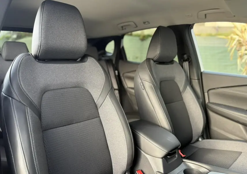 Vue intérieure rapprochée des sièges avant en tissu gris et noir du Nissan Qashqai III e-Power 2025.