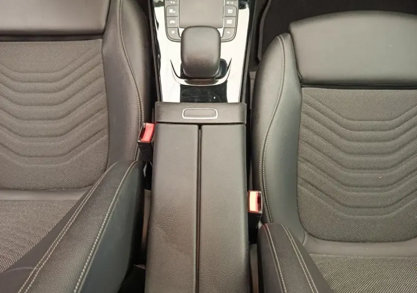 Vue plongeante sur la console centrale et les sièges avant en cuir noir de la Mercedes Classe A A 180 Business Line 2020.
