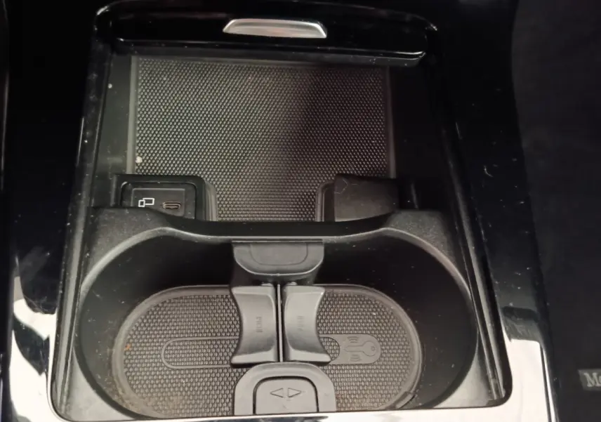 Gros plan sur la console centrale noire de la Mercedes Classe A 180 Business Line avec porte-gobelets et prise USB visible.