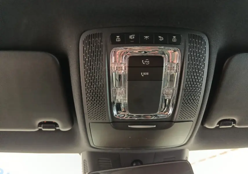 Vue en plongée sur le plafonnier noir avec commandes SOS et éclairage intérieur de la Mercedes Classe A gris clair.