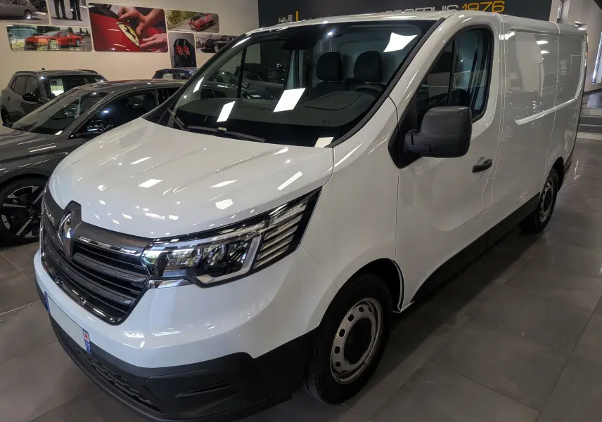 Vue 3/4 avant droit du Renault Trafic Fourgon blanc minéral 2024, avec calandre chromée et optiques modernes.