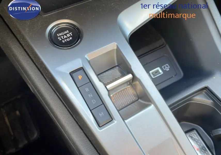 Gros plan sur la console centrale de la Peugeot 308 SW Hybrid 2025, montrant le bouton start/stop et la commande de boîte automatique.