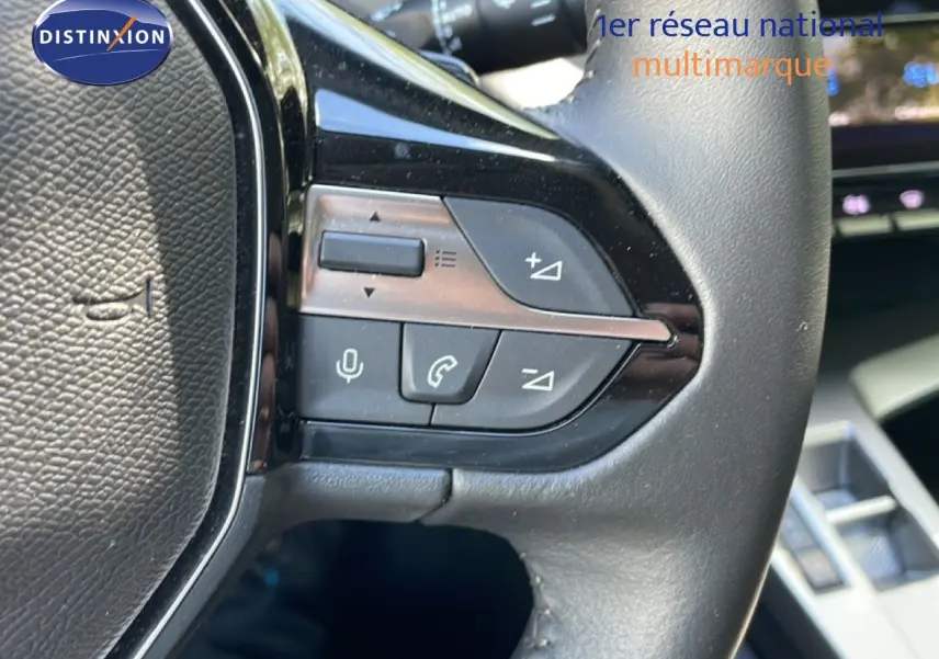 Gros plan sur les commandes multifonctions au volant cuir noir du Peugeot 308 SW Hybrid gris Artense 2025.