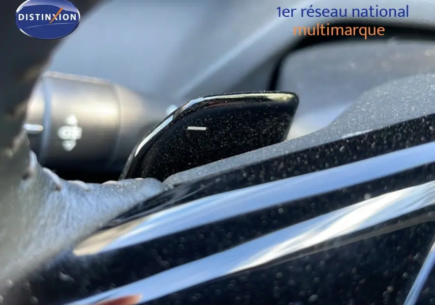 Gros plan sur la palette de changement de vitesse noire à l'intérieur d'une Peugeot 308 SW gris Artense hybride.