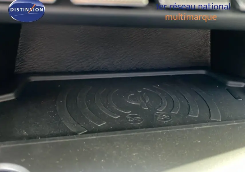 Détail du chargeur à induction dans l'habitacle de la Peugeot 308 SW Hybrid 145ch gris Artense, vue rapprochée intérieure.