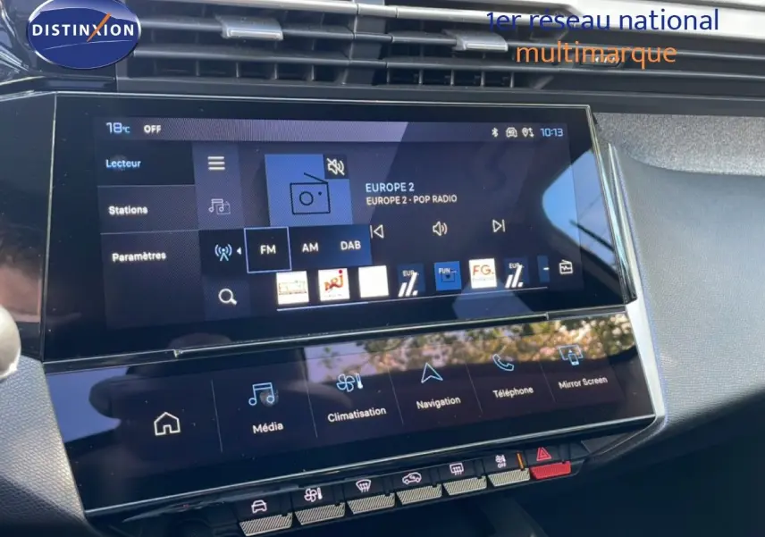 Vue rapprochée de l’écran tactile central du tableau de bord de la Peugeot 308 SW gris Artense, affichant la radio FM.
