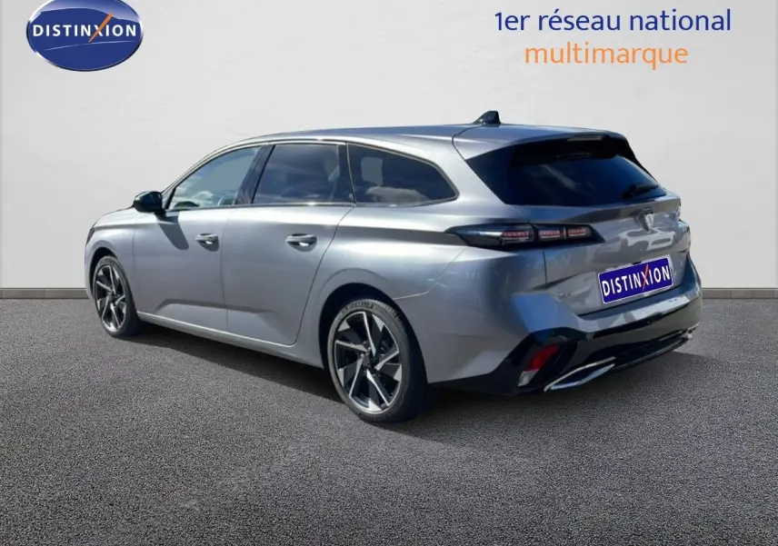 Vue 3/4 arrière droite d'une Peugeot 308 SW Hybrid gris Artense métallisé avec jantes alliage et vitres teintées.