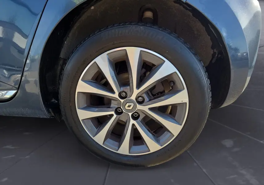 Gros plan sur la roue avant droite d’une Renault Clio V gris foncé métal, jante alliage à plusieurs branches.