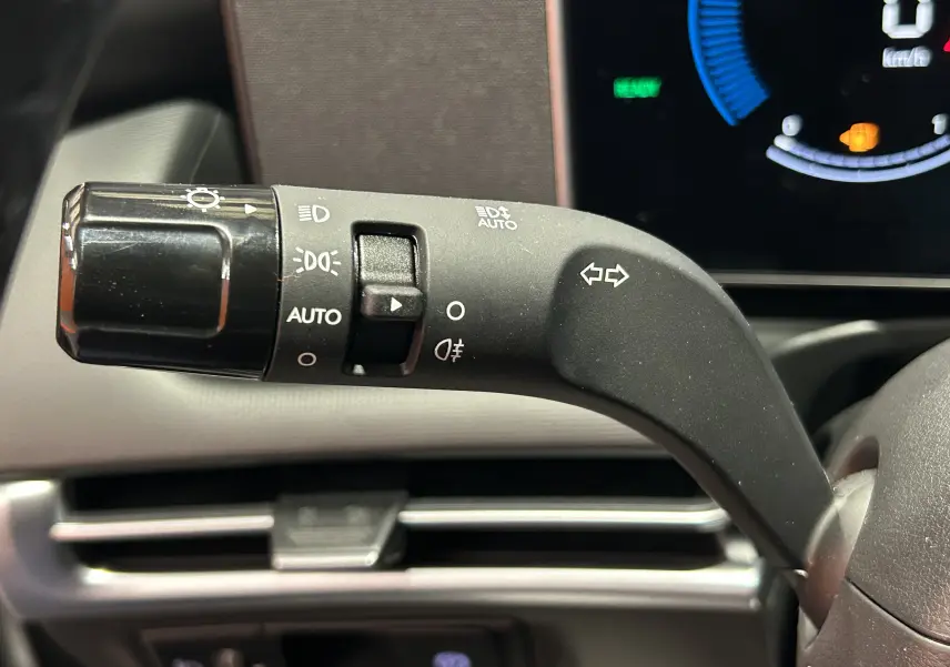 Gros plan sur la manette de clignotants à gauche du volant du Hyundai Tucson 2025 finition Style en intérieur noir.