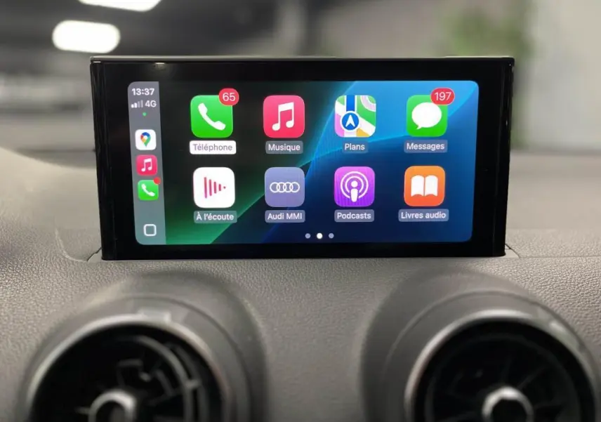 Écran tactile central de l'Audi Q2 2022 affichant l'interface Apple CarPlay avec commandes multimédia visibles.