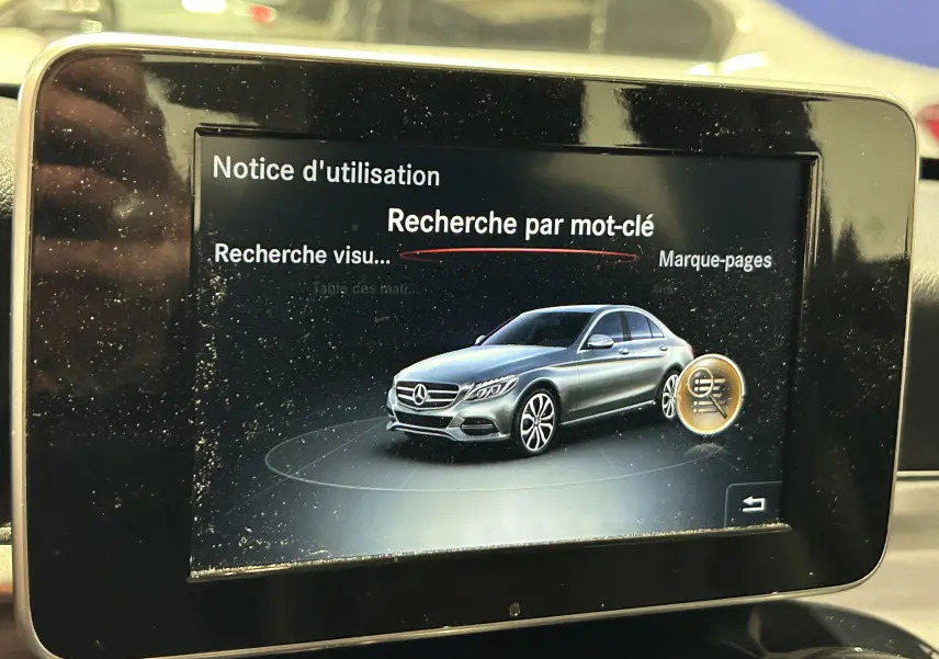 Écran multimédia affichant une illustration latérale droite d'une Mercedes Classe C bleue sur fond noir.