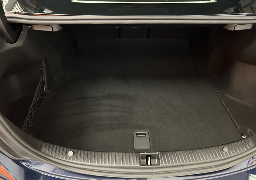 Coffre ouvert vu de dessus d'une Mercedes Classe C 200d bleu, montrant un espace de rangement propre et vide.