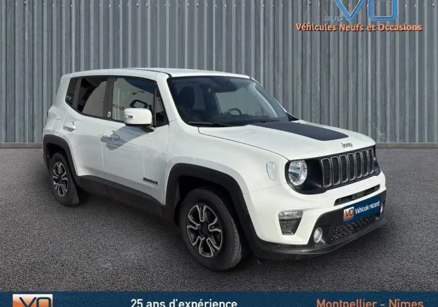 Jeep Renegade blanc en 3/4 avant droit avec capot noir et jantes alliage 17 pouces, stationné devant un mur métallique.