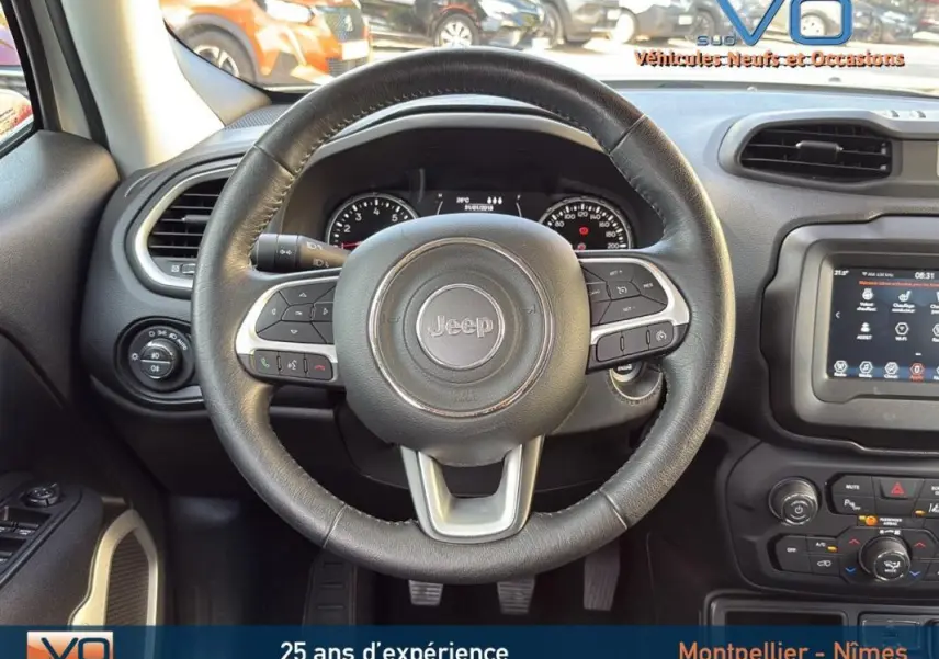 Vue centrée sur le volant cuir du Jeep Renegade blanc, avec tableau de bord et écran tactile visibles.