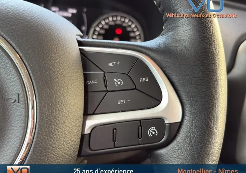 Gros plan sur les commandes du régulateur de vitesse au volant d'une Jeep Renegade 2020, intérieur noir.