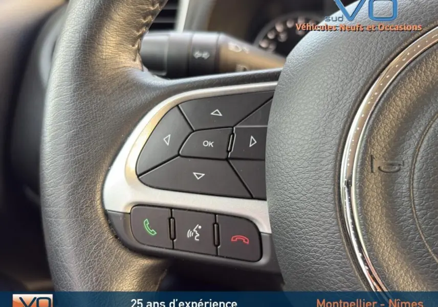 Gros plan sur les commandes multifonctions du volant cuir noir du Jeep Renegade blanc 2020.
