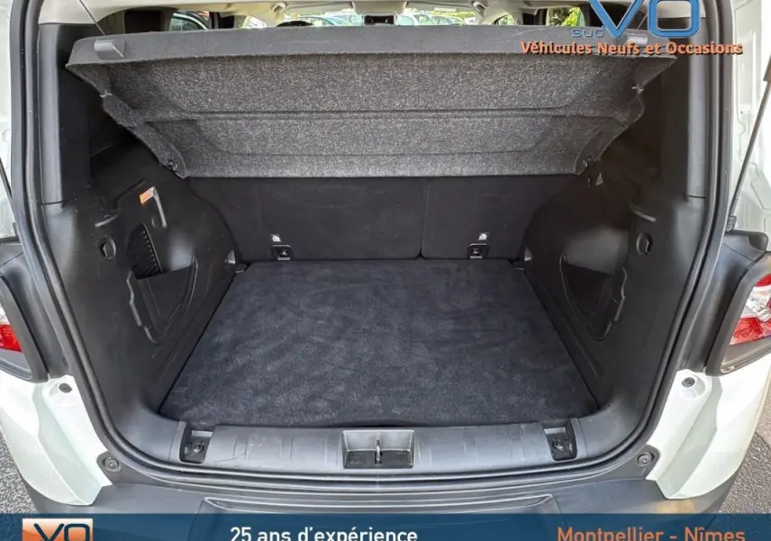 Coffre ouvert du Jeep Renegade blanc 2020, vue arrière montrant l'espace de chargement vide et la tablette cache-bagages relevée.