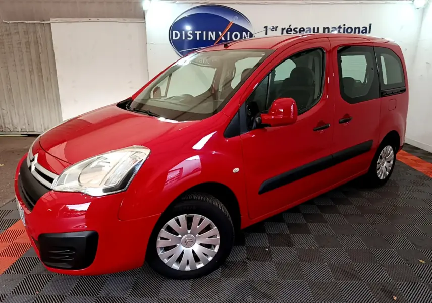 Vue 3/4 avant droit d'un Citroën Berlingo rouge de 2016 avec protections noires et jantes acier à enjoliveurs.