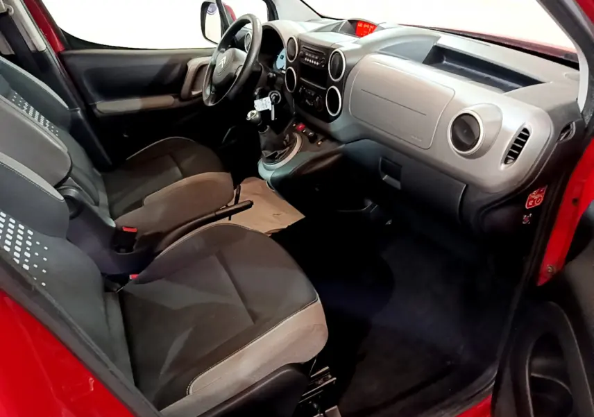 Vue intérieure côté conducteur du Citroën Berlingo rouge 2016, montrant tableau de bord et sièges avant gris.