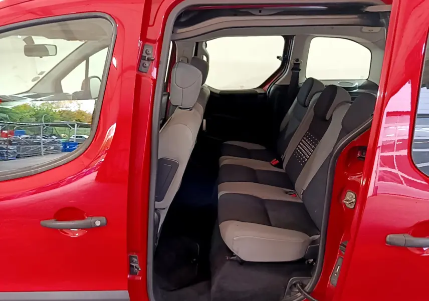 Vue latérale gauche du Citroën Berlingo rouge 2016 montrant les sièges arrière gris et noirs avec porte coulissante ouverte.