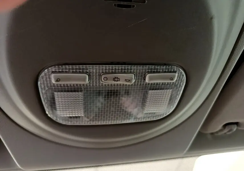 Plafonnier intérieur avec commandes d'éclairage dans une Citroën Berlingo rouge, vue en gros plan depuis l'habitacle.